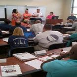 Selma, Ala., July 17, 2013 -- Members of the Dallas County, Ala., community participate in the Integrated Emergency Management Course (IEMC) conducted July 15-18, 2013, at the Alabama Criminal Justice Training Center. This group represents the Policy Group during a table top exercise. The IEMC builds awareness and skills needed to develop and implement policies, plans and procedures in an Emergency Operations Center to protect life and property.